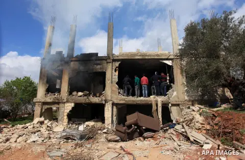 Palestinians inspect the damaged house of Palestinian Moataz Washaha, who died during an Israeli army raid on his home in in the West Bank village of Birzeit, near Ramallah February 27, 2014. Israeli forces opened fire a...