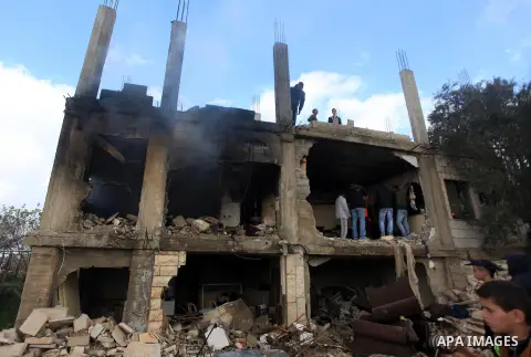 Palestinians inspect the damaged house of Palestinian Moataz Washaha, who died during an Israeli army raid on his home in in the West Bank village of Birzeit, near Ramallah February 27, 2014. Israeli forces opened fire a...