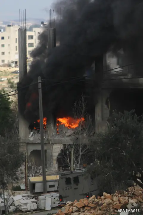 Flames rise from the house of Palestinian Moataz Washaha, who died during an Israeli army raid on his home in the northern West Bank town of Bir Zeit, near Ramallah on February 27, 2014. Israeli forces opened fire and ki...