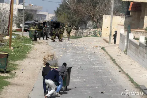 Palestinian youth throw stones at Israeli soldiers during clashes in the West Bank village of Birzeit, near Ramallah February 27, 2014. The clashes broke out after Israeli forces opened fire and killed a Palestinian they...