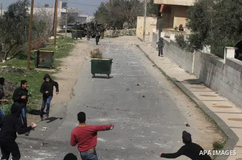 Palestinian youth throw stones at Israeli soldiers during clashes in the West Bank village of Birzeit, near Ramallah February 27, 2014. The clashes broke out after Israeli forces opened fire and killed a Palestinian they...