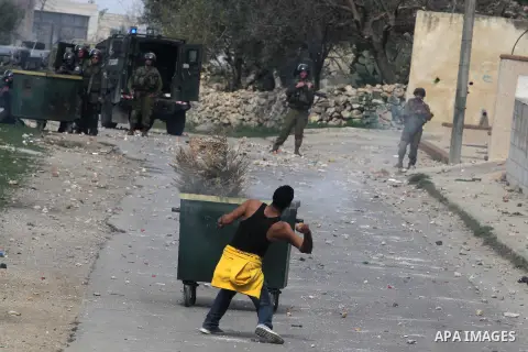A Palestinian youth throws stones at Israeli soldiers during clashes in the West Bank village of Birzeit, near Ramallah February 27, 2014. The clashes broke out after Israeli forces opened fire and killed a Palestinian t...