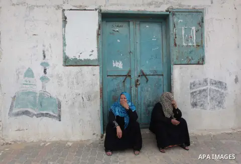 Palestinian relatives mourn on the body of Amena Atiyyeh Qudeih, a mentally ill Gazan woman who was shot dead by Israeli troops near the border early on March 1, 2014, the Palestinian territory's Hamas-run health ministr...