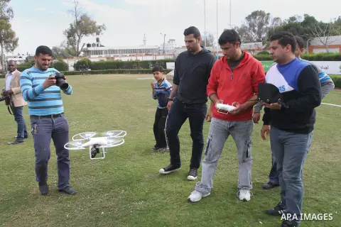 Palestinian youths control by remote control the drone plane with a camera during a test at al Yarmouk Stadium in Gaza city, on March 1, 2014. Palestinian company "Media Town" imported a drone plane is dedicated to film...