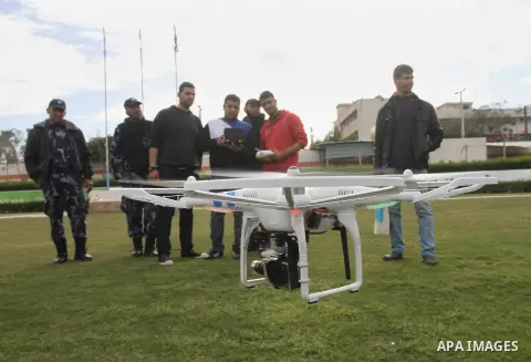 Palestinian youths control by remote control the drone plane with a camera during a test at al Yarmouk Stadium in Gaza city, on March 1, 2014. Palestinian company "Media Town" imported a drone plane is dedicated to film...