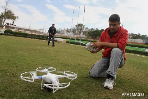 A Palestinian youth controls by remote control the drone plane with a camera during a test at al Yarmouk Stadium in Gaza city, on March 1, 2014. Palestinian company "Media Town" imported a drone plane is dedicated to fil...