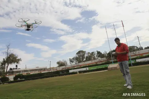 A Palestinian youth controls by remote control the drone plane with a camera during a test at al Yarmouk Stadium in Gaza city, on March 1, 2014. Palestinian company "Media Town" imported a drone plane is dedicated to fil...