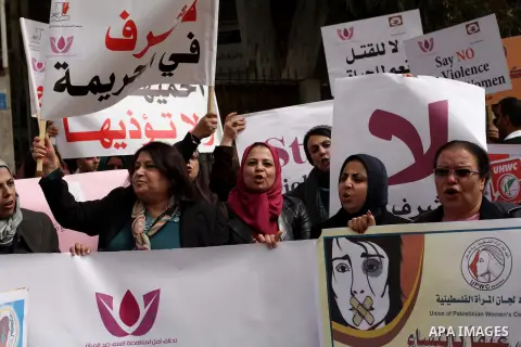 Palestinian women hold placards and shout slogans during a rally to protest against the rising incidents of violence against women in Gaza City March 03, 2014. Twenty-six women were slain by relatives in the West Bank an...