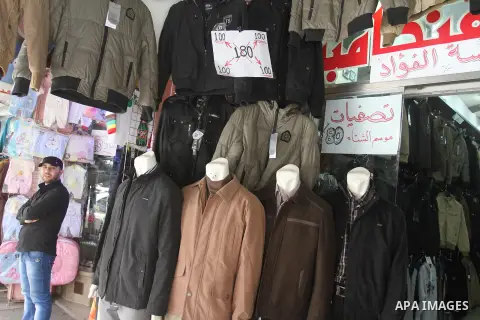 A Palestinian vendor displays his goods at shop in Gaza city, on March 1, 2014. Palestinian vendors campaign discounts on prices of clothes to confront the sharp reduction in demand due to the blockaded territory’s econo...