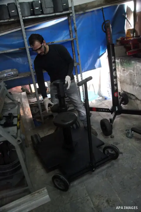 Imad al-Kronz, a Palestinian man works on an camera crane, at his workshop in al-Arrub refugee camp, near the West Bank City of Hebron, March 07, 2014. al-Kronz, studies the journalism and he have a hobby to make all of...