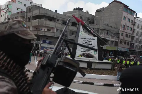 Palestinian members of al-Qassam Brigade, the military wing of Hamas movement, stand in front of a monument of a homemade M75 rocket in the middle of a square in Gaza City March 10, 2014. Hamas fired M75 rockets at Tel A...