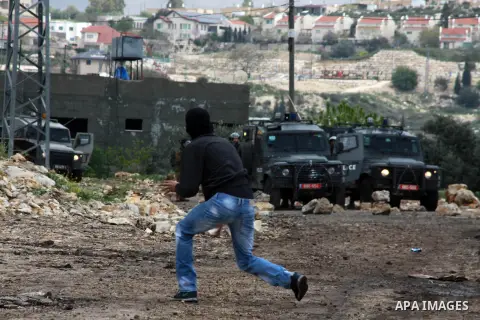 A Palestinian protester throws stones at Israeli security forces as clashes broke out during a demonstration against the expropriation of Palestinian land by Israel in the village of Kfar Qaddum, near the occupied West B...