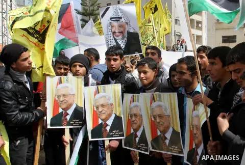 Palestinian Fatah supporters hold placards showing pictures of President Mahmoud Abbas and late leader Yasser Arafat during a rally in support of Abbas in the West Bank village of Tubas near Jenin March 16, 2014. With pe...