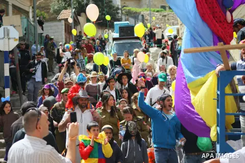 Dressed up Israelis take part in a parade to celebrate the Jewish holiday of Purim in al-Shuhada street, in the West Bank town of Hebron, on March 16, 2014. The carnival-like Purim holiday is celebrated with parades and...