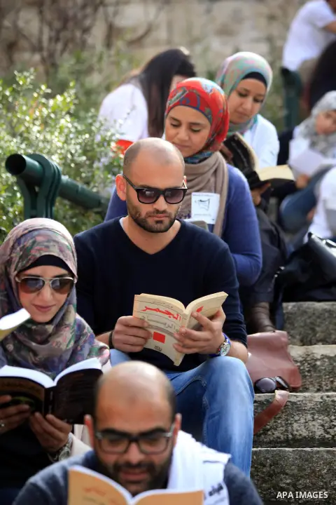 Palestinian activists participate in a reading human chain in Jerusalem's Old City, 16 March 2014. About than 7000 Palestinian activists gathered in the longest reading human chain arround the Old City walls, coincides w...