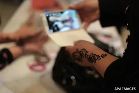 A Palestinian woman gets her hands decorated with traditional henna during an exhibition entitled "Products of our women" in Gaza City on March 17, 2014. Photo by Ashraf Amra
