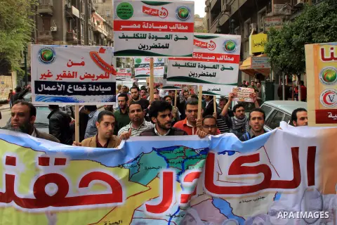 Egyptian doctors and pharmacists hold placards during a demonstration demanding for the application of the minimum wage, in Cairo on March 18, 2014. Egyptian medical professionals rejected the proposal of Minister of Hea...