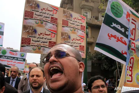 Egyptian doctors and pharmacists hold placards during a demonstration demanding for the application of the minimum wage, in Cairo on March 18, 2014. Egyptian medical professionals rejected the proposal of Minister of Hea...
