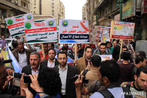 Egyptian doctors and pharmacists hold placards during a demonstration demanding for the application of the minimum wage, in Cairo on March 18, 2014. Egyptian medical professionals rejected the proposal of Minister of Hea...