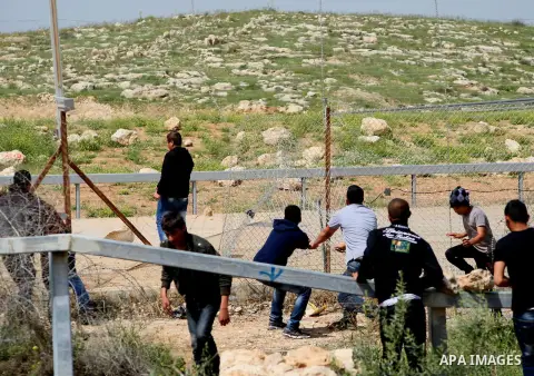 Palestinian youths throw stones at Israeli security forces during clashes at the site where Palestinian youth Yussef Shawamreh was shot by Israeli forces near the West Bank village of Deir al-Asal, 15 kilometres from Heb...