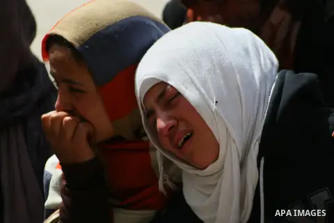 Relatives of Palestinian teenager Yussef Shawamreh mourn outside his house in the West Bank village of Deir al-Asal, 15 kilometres from Hebron on March 19, 2014 after he was shot by Israeli troops in the occupied West Ba...