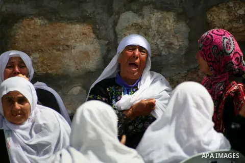 Relatives of Palestinian teenager Yussef Shawamreh mourn outside his house in the West Bank village of Deir al-Asal, 15 kilometres from Hebron on March 19, 2014 after he was shot by Israeli troops in the occupied West Ba...