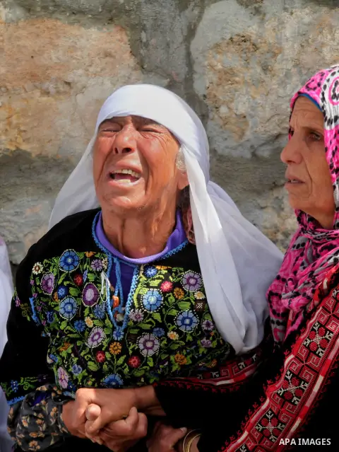 Relatives of Palestinian teenager Yussef Shawamreh mourn outside his house in the West Bank village of Deir al-Asal, 15 kilometres from Hebron on March 19, 2014 after he was shot by Israeli troops in the occupied West Ba...
