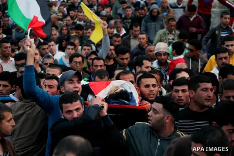 Palestinian mourners carry the body of 15-year-old Yussef Sami Shawamreh, shot dead by Israeli troops, during his funeral in the village of Deir al-Asal al-Tahta, some 15 kilometres (nine miles) southwest of the West Ban...