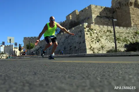 Local and international runners take part in the annual Jerusalem Marathon in the Old City on March 21, 2014. More than 15,000 runners from 50 different countries participated in the annual sporting event included runnin...