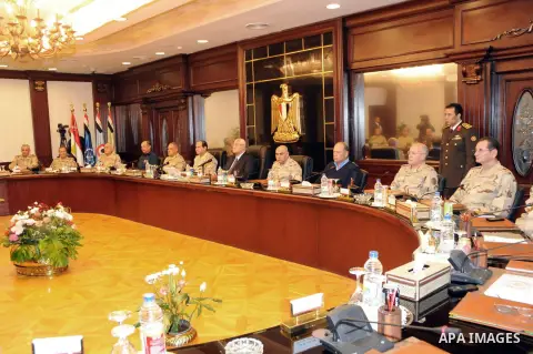 Egypt's interim President Adly Mansour (L, in suit and tie) meets with Egypt's army chief Field Marshal Abdel Fattah al-Sisi (seated next to Mansour) and military leaders, in Cairo March 26, 2014. Egypt's military leader...