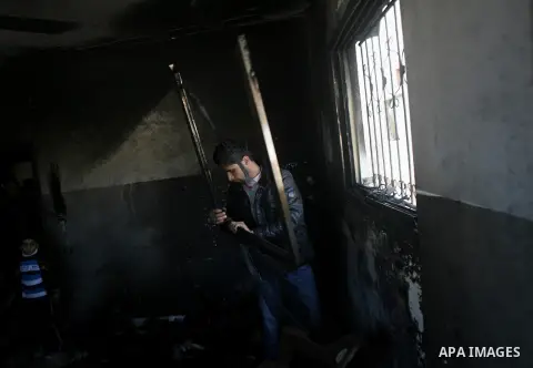 A Palestinian man inspects the damage in the room after a fire swept over a house in Rafah sothern in Gaza city on March 27, 2014. Gaza residents often use candles to light their house during frequent power cuts, which c...