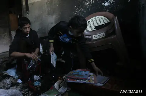 Palestinians inspect the damage in the room after a fire swept over a house in Rafah sothern in Gaza city on March 27, 2014. Gaza residents often use candles to light their house during frequent power cuts, which can las...