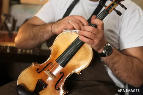 Palestinian musical instrument maker Shehdeh Shalaldeh, works on a component for a violin at his workshop for stringed instruments, in the West Bank city of Ramallah, March 27, 2014. Photo by Issam Rimawi