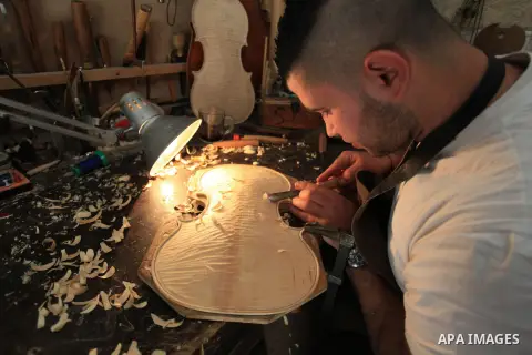 Palestinian musical instrument maker Shehdeh Shalaldeh, works on a component for a violin at his workshop for stringed instruments, in the West Bank city of Ramallah, March 27, 2014. Photo by Issam Rimawi