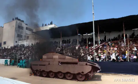 A picture shows burn a tank during a military graduation ceremony in Gaza City on April 02, 2014. 1200 officers graduated from advanced training courses that lasted one year in Gaza police academy. Photo by Ashraf Amra