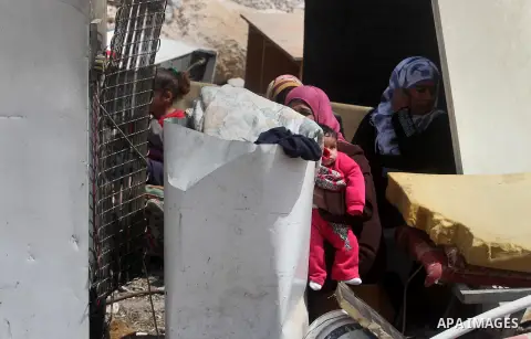 Palestinian Bedouins sit amid the rubble of tents and sheds demolished by the Israeli army in Al-Azariya, on the outskirts of Jerusalem, on April 3, 2014, on the grounds that it was built without a construction permitt....