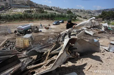 A Palestinian Bedouin man looks through the rubble of tents and sheds demolished by the Israeli army in Al-Azariya, on the outskirts of Jerusalem, on April 3, 2014, on the grounds that it was built without a construction...
