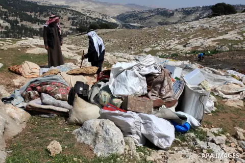 Palestinian Bedouin men look through the rubble of tents and sheds demolished by the Israeli army in Al-Azariya, on the outskirts of Jerusalem, on April 3, 2014, on the grounds that it was built without a construction pe...