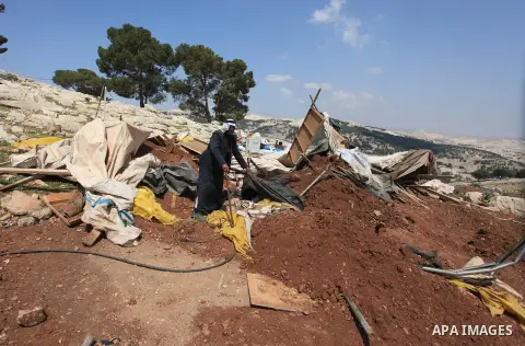 A Palestinian Bedouin man looks through the rubble of tents and sheds demolished by the Israeli army in Al-Azariya, on the outskirts of Jerusalem, on April 3, 2014, on the grounds that it was built without a construction...