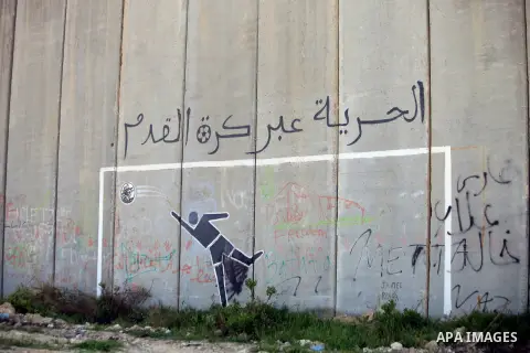 A graffiti of football player is seen on the Israeli controversial separation barrier from the Jerusalem side of the east Jerusalem village of Abu Dis, April 03, 2014. Talks between Israeli and Palestinian negotiators ar...