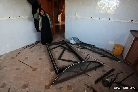 A Palestinian woman inspects her house following an overnight Israeli air strike on a nearby land in the central Gaza Strip April 4, 2014. After Israel called off the planned release of 26 Palestinian prisoners the day b...
