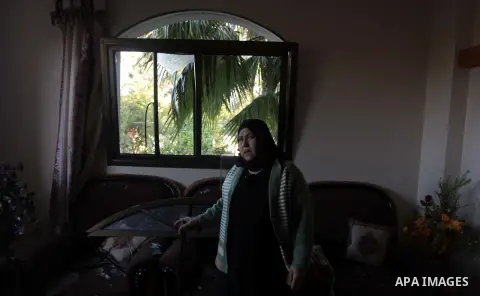 A Palestinian woman inspects her house following an overnight Israeli air strike on a nearby land in the central Gaza Strip April 4, 2014. After Israel called off the planned release of 26 Palestinian prisoners the day b...