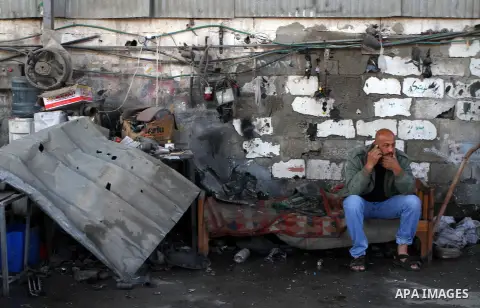 A Palestinian man speaks on the phone at his cars workshop following an overnight Israeli air strike on Jabalia in the northern Gaza Strip, on April 4, 2014. After Israel called off the planned release of 26 Palestinian...