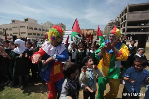 Palestinian clowns play with children in a rally marking the Children's Day during a protest against Israeli blockade on Gaza strip in Gaza city, on April 05, 2014. Photo by Ashraf Amra