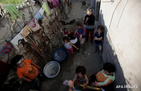 Palestinian children play outside their house, in Gaza city on April 05, 2014. Marking children's day, statistics show 50% of the population of the Gaza Strip under 18 years, 56% of them Living in poverty. Photo by Ezz a...