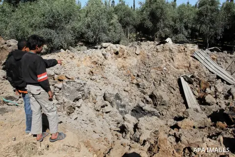 Palestinians look on the damage following an Israeli air strike at agricultural land in Beit Hanoun in the northern Gaza Strip, on April 6, 2014. Israeli warplanes attacked several sites in the Gaza Strip Sunday, sources...