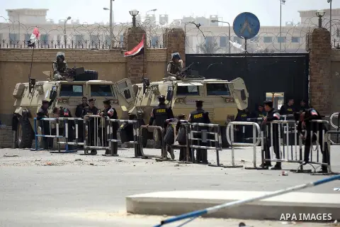 Egyptian security forces stand guard outside Police Academy, where the trial of ousted President Mohamed Mursi held, in Cairo April 06, 2014. The court which is trying Morsi and 14 others on charges of inciting the murde...