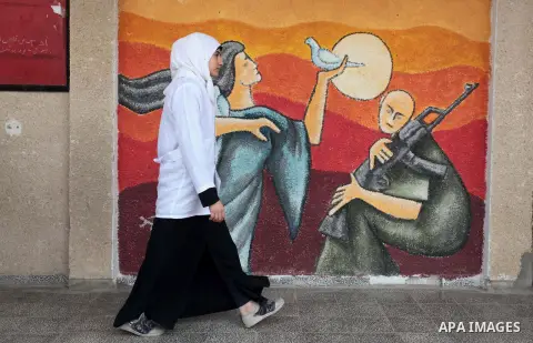 A Palestinian student walks past a mural during a lecture to students the dangers of unexploded ammunition, at a school in Khan Younis in the southern Gaza Strip April 7, 2014. Photo by Ashraf Amra