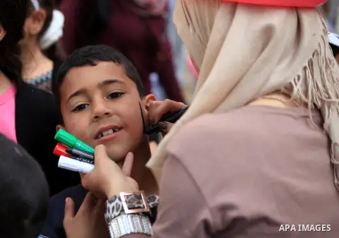 A Palestinian boy has his national flag painted on his face during a celebration marking the International children's Day, in Jerusalem on April 7, 2014. Photo by Saeed Qaq
