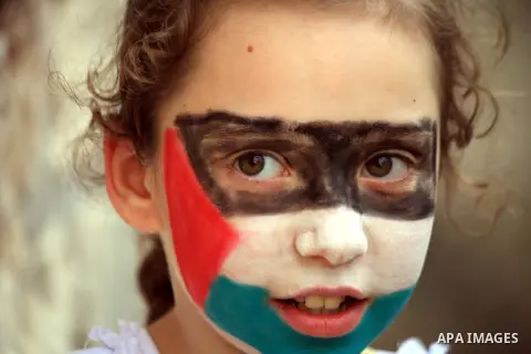 A Palestinian girl with her national flag painted on her face takes part in a celebration marking the International children's Day, in Jerusalem on April 7, 2014. Photo by Saeed Qaq